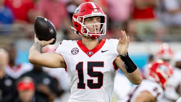 Georgia Bulldogs quarterback Carson Beck attempts a pass during a college football game in the SEC.